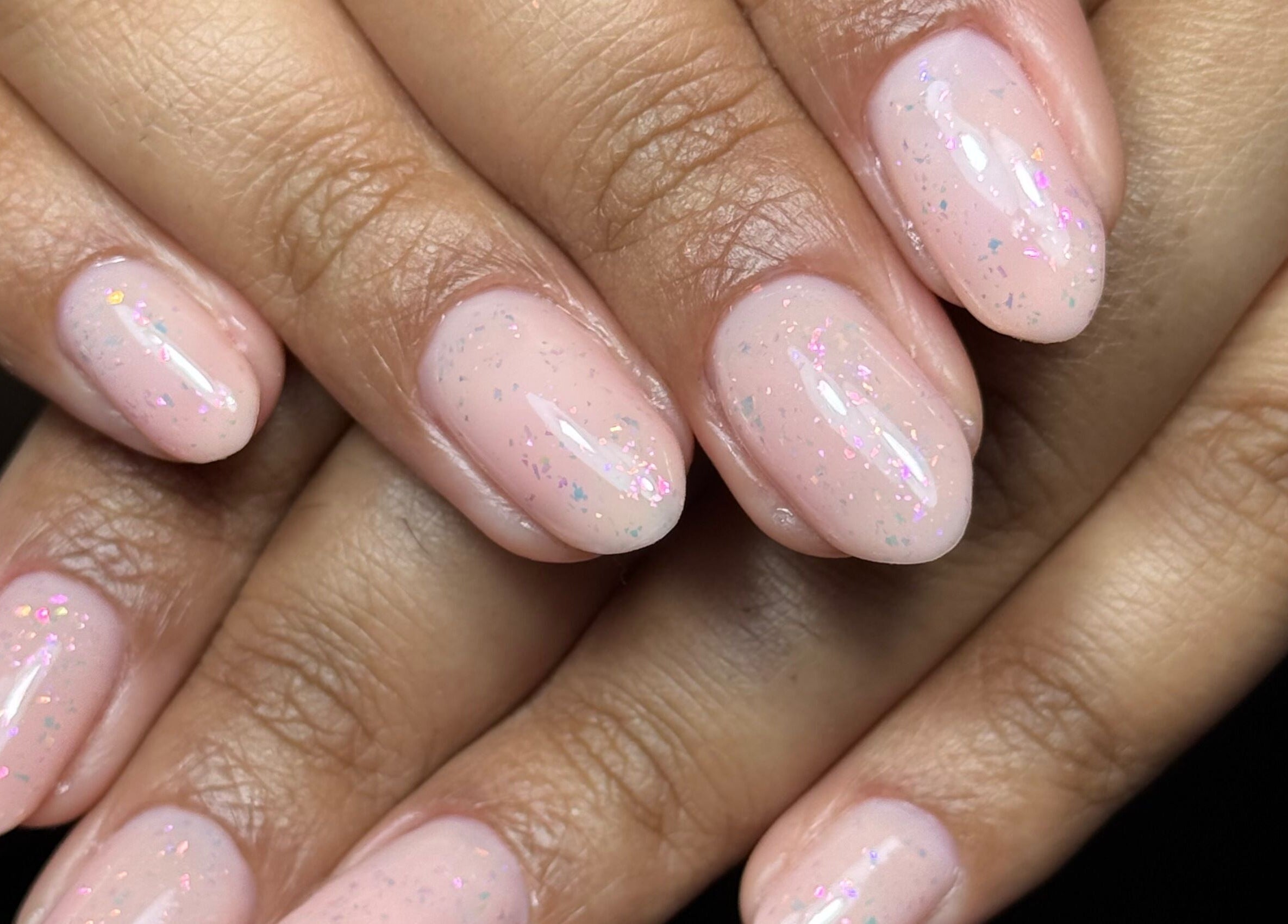 Elegant pastel nail art at Nails by Estee, Horsham, England, GB. Soft pink polish with subtle sparkle.