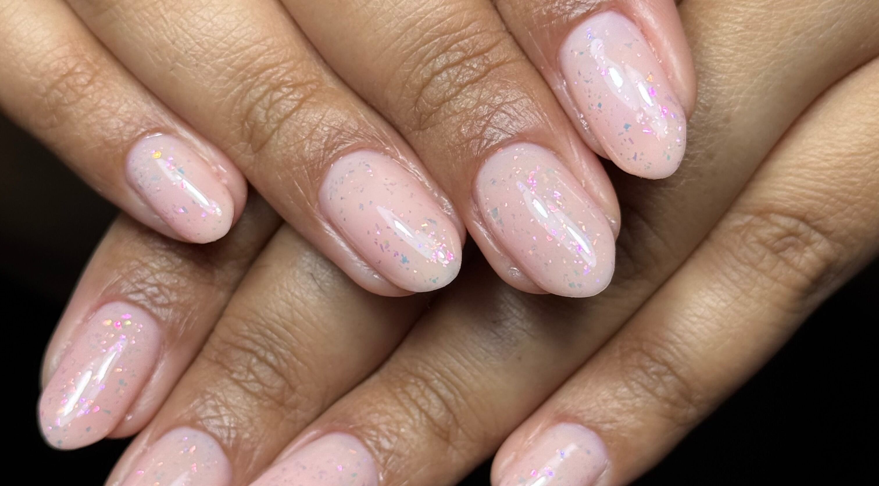 Elegant pastel nail art at Nails by Estee, Horsham, England, GB. Soft pink polish with subtle sparkle.