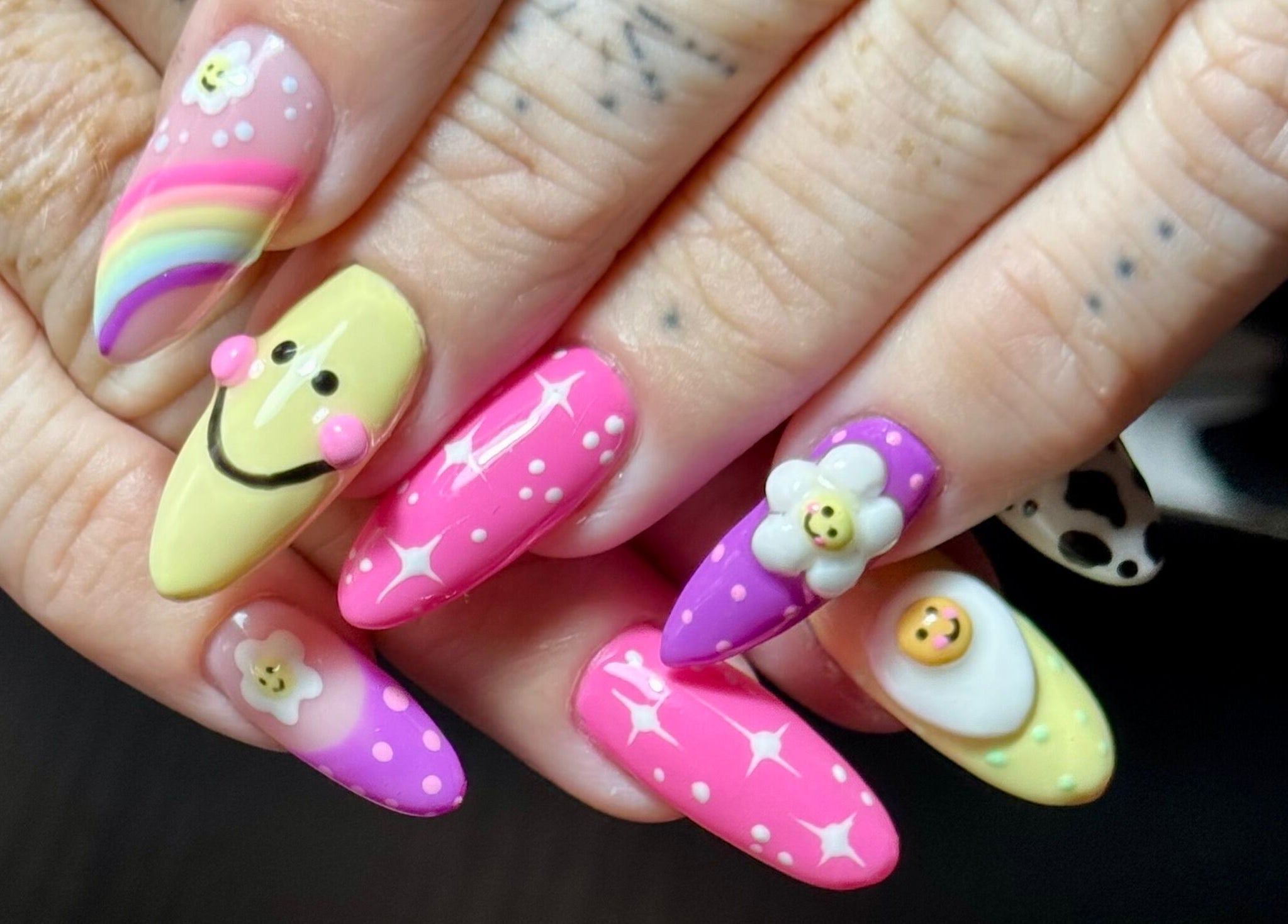 Whimsical nail art at Nails by Estee in Horsham, England, GB featuring colorful smile and flower designs.