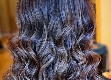Stylish wavy hairstyle at G'wan Hairstylist, London, England, GB, showcasing elegant curls and glossy shine.