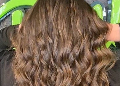 Elegant wavy hairstyle crafted at G'wan Hairstylist in London, England, GB, showcasing rich, glossy hair.