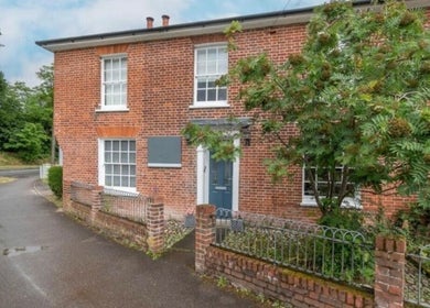 Exterior view of The Lash Lounge in Fakenham, England, GB showcasing a charming red brick facade with greenery.