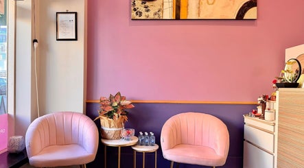 Elegant lounge area at Pailin Thai Wellness, South Yarra, Victoria, AU featuring soft pink chairs and decor.