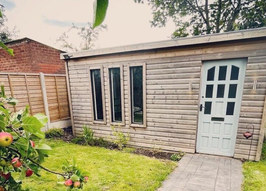 Charming garden cabin at Breathe and Bloom Holistics in Wakefield, England, GB, surrounded by lush greenery.