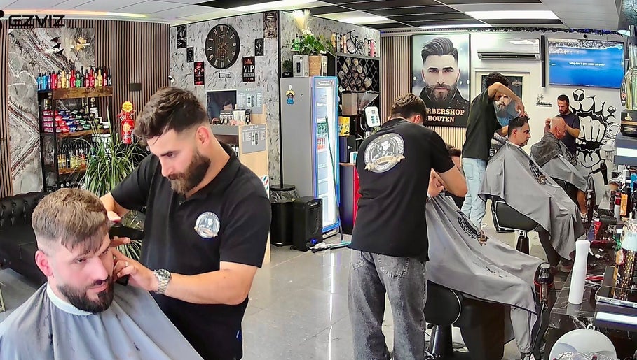 Kappers aan het werk bij Barbershop Houten, Houten, Utrecht, NL, met moderne inrichting en styling.