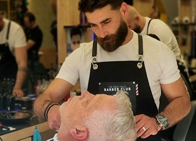 Stijlvolle barber in Barbershop Houten, Houten Utrecht, NL geeft klant een klassieke scheerbeurt.