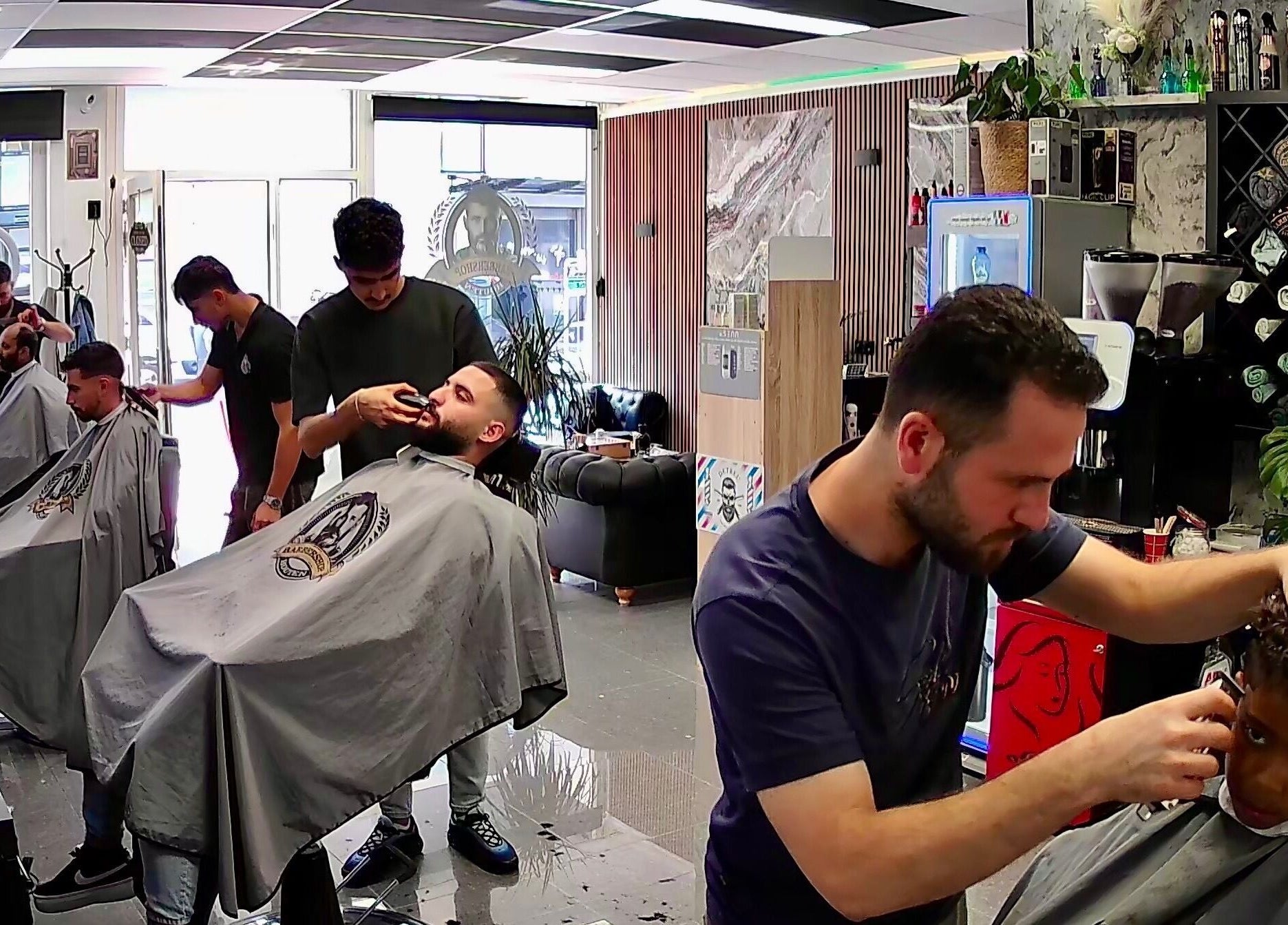 Kappers aan het werk bij Barbershop Houten, Houten, Utrecht, NL. Moderne en stijlvolle kapsalon ambiance.