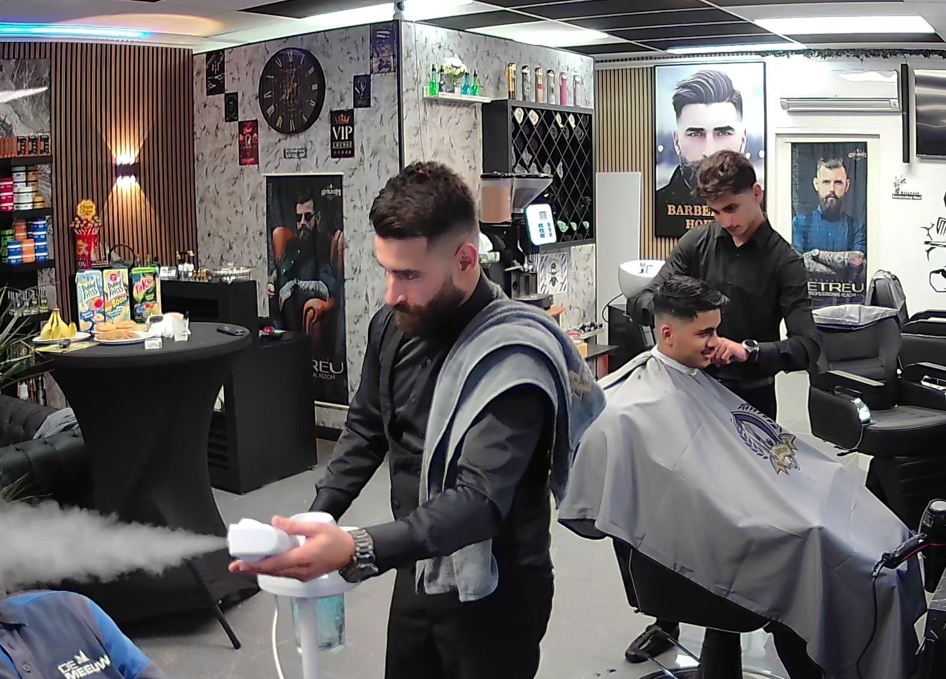 Interieur van Barbershop Houten in Houten, Utrecht, NL met klanten in stoelen en stoombad.