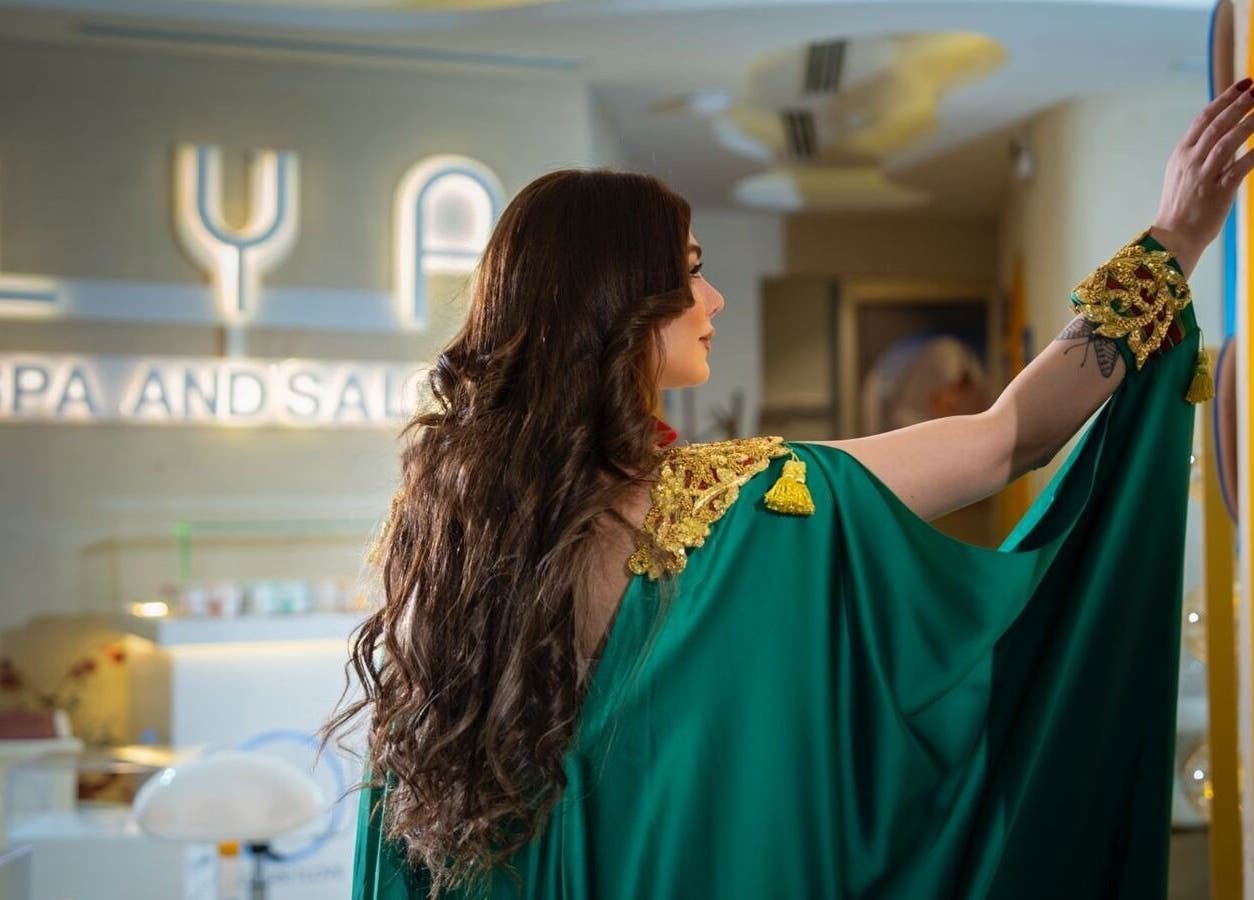 Woman in green robe admiring LYA Spa & Salon in Riyadh, Riyadh Province, SA.