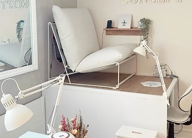 Coin beauté élégant chez Beauty Home Concept à Amiens, France, FR, avec fauteuil moderne et lampe design.