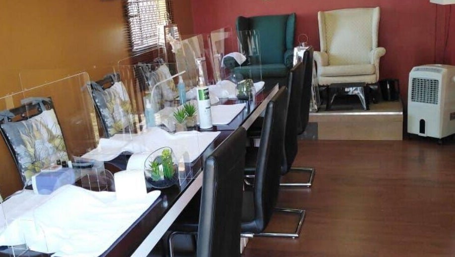 Nail stations at Modi Fi Nail And Beauty Bar in Soweto, Gauteng, ZA, featuring chic decor and comfortable seating.