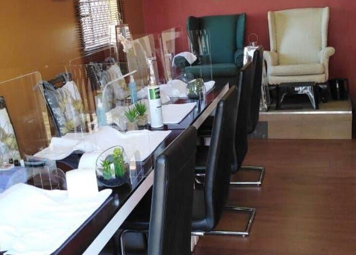 Nail stations at Modi Fi Nail And Beauty Bar in Soweto, Gauteng, ZA, featuring chic decor and comfortable seating.