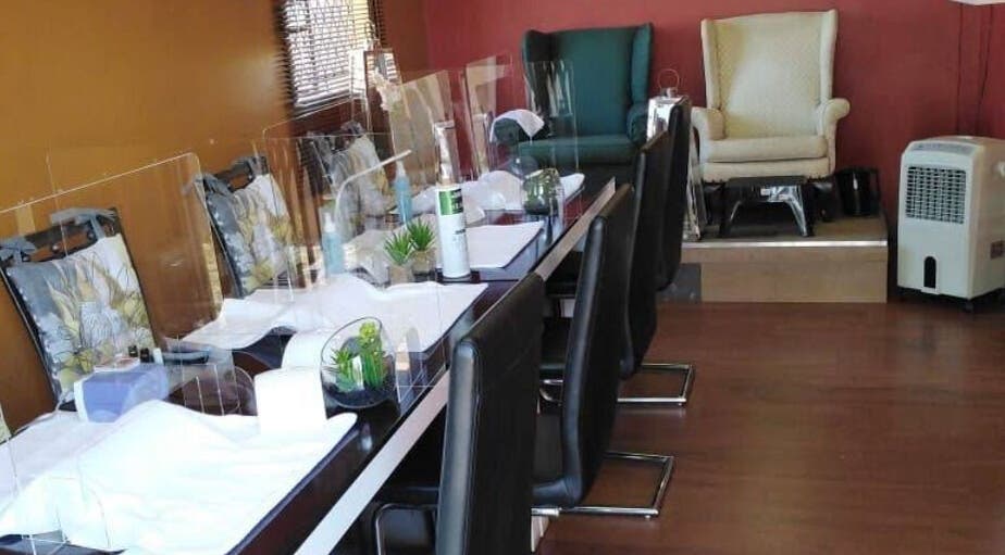 Nail stations at Modi Fi Nail And Beauty Bar in Soweto, Gauteng, ZA, featuring chic decor and comfortable seating.