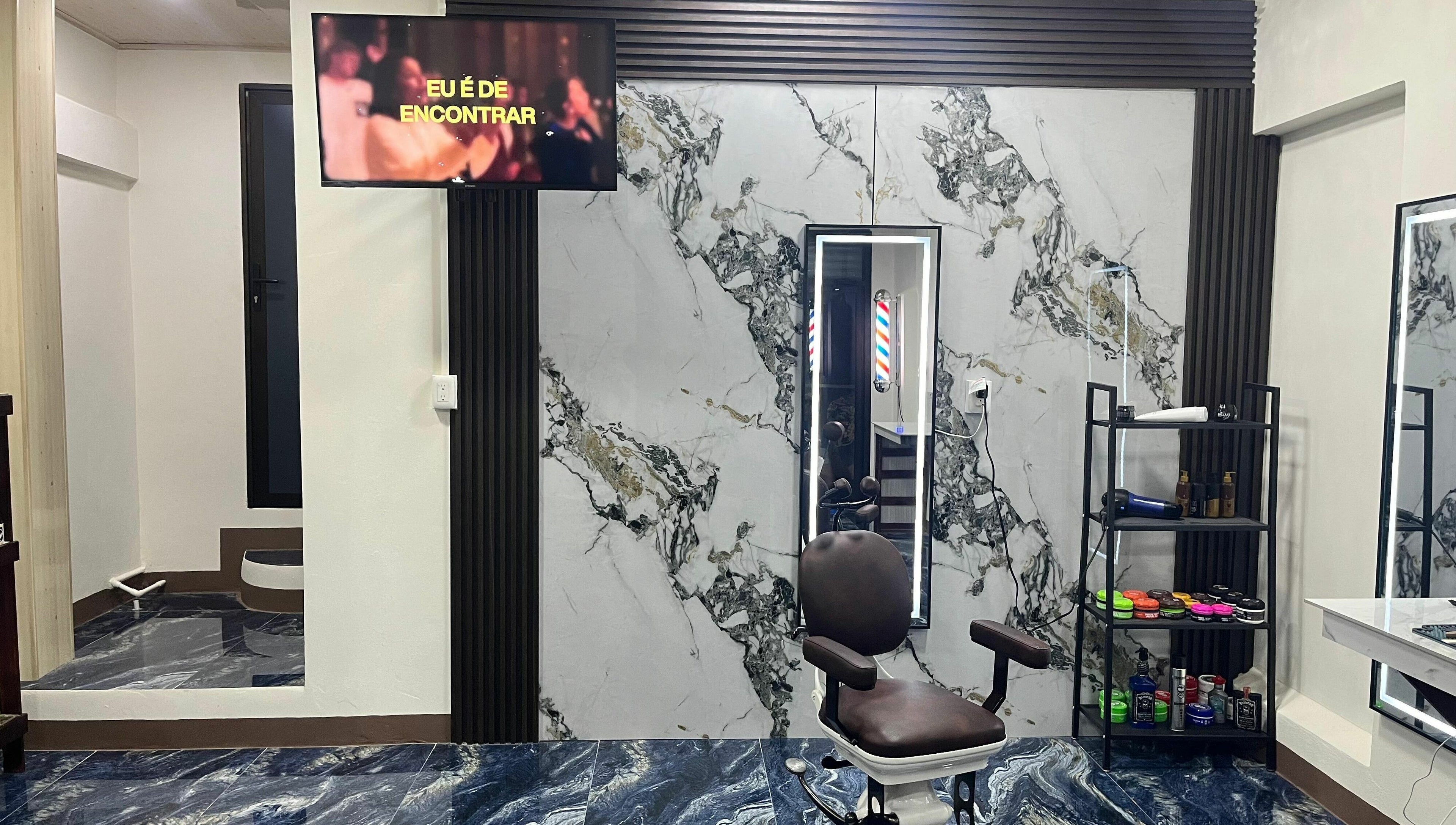 Interior de G Matices Barber en Guápiles, Limón, CR con silla de barbero y espejo iluminado.