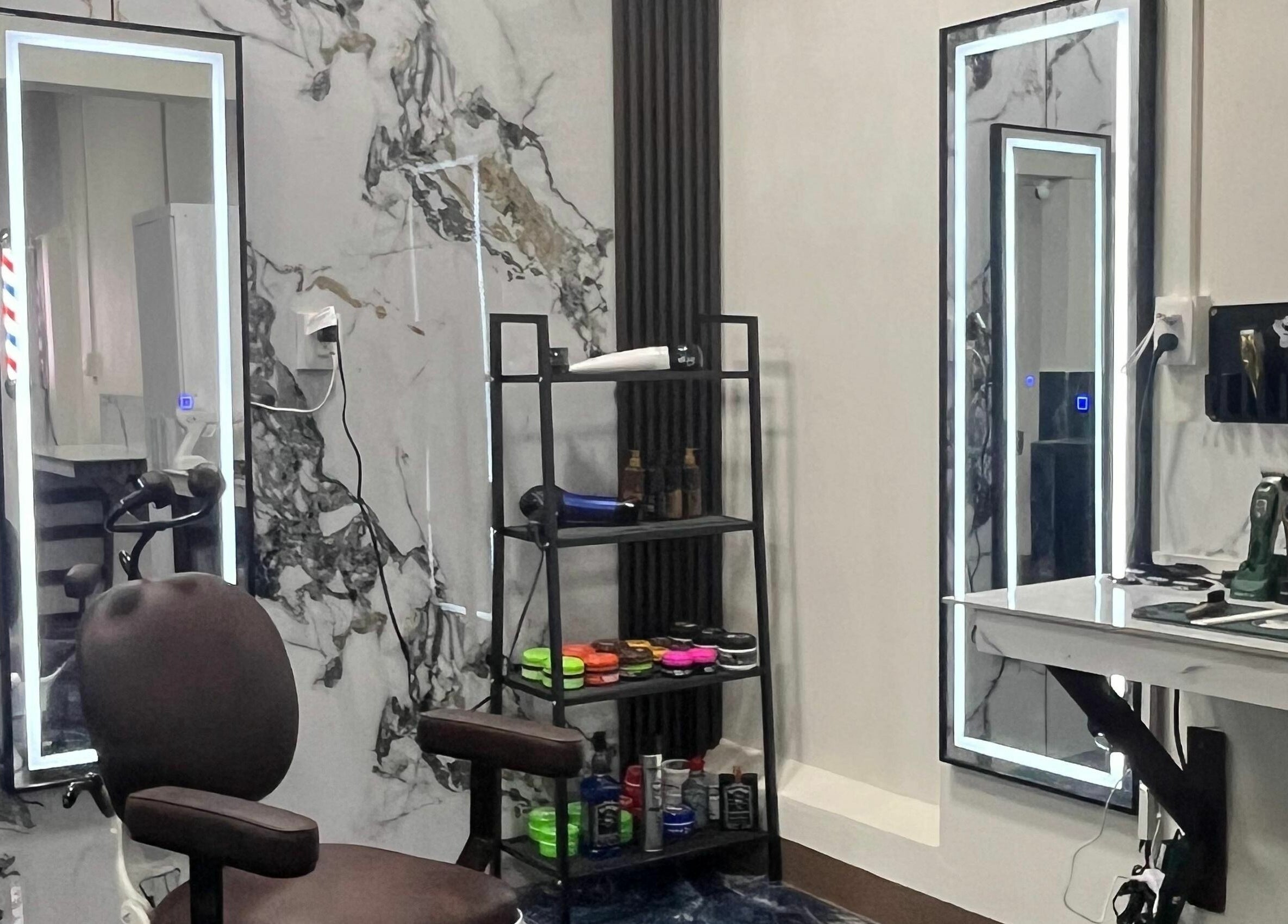 Estación de trabajo moderna en G Matices Barber, Guápiles, Limón, CR, con espejo, silla y productos de belleza.