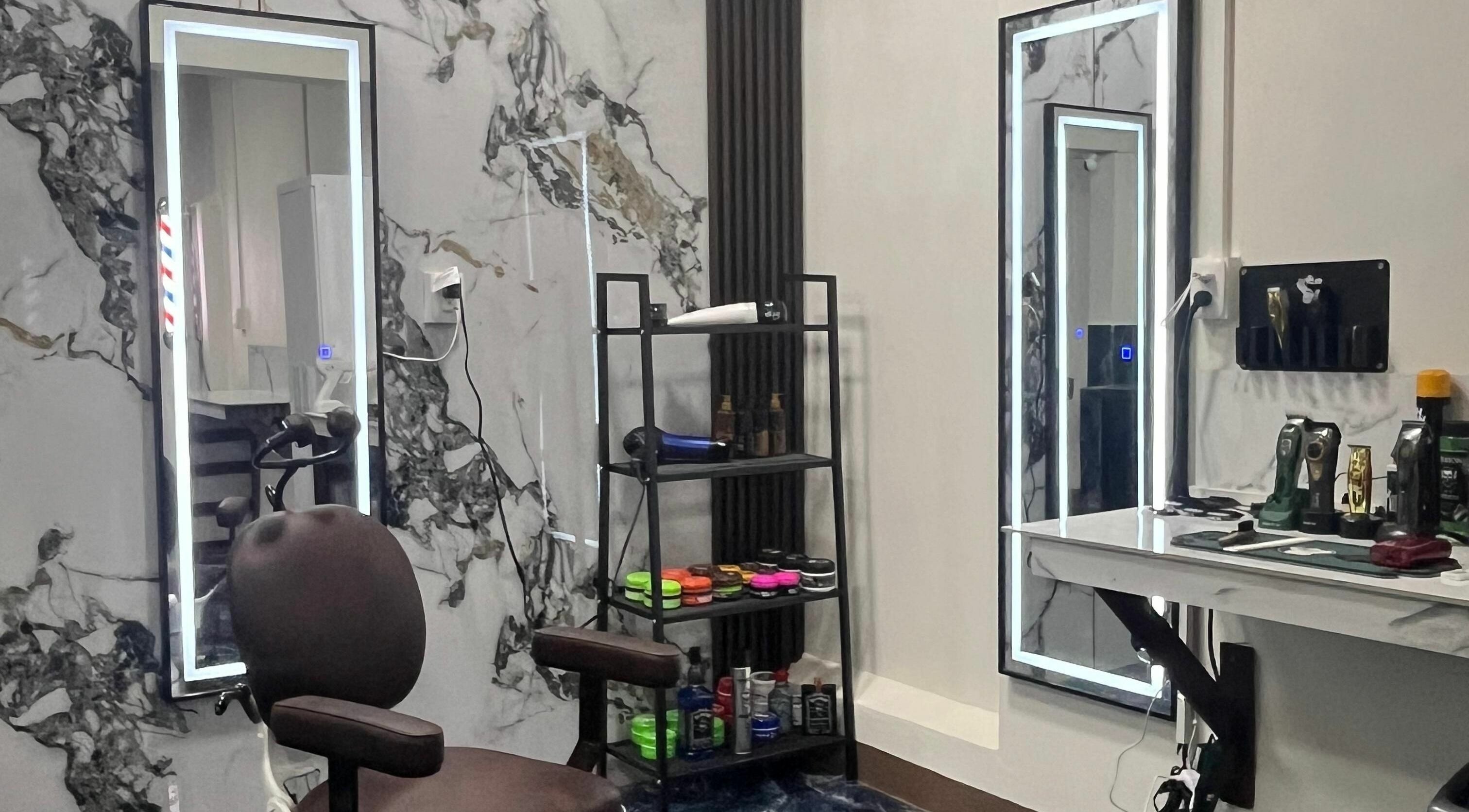 Estación de trabajo moderna en G Matices Barber, Guápiles, Limón, CR, con espejo, silla y productos de belleza.