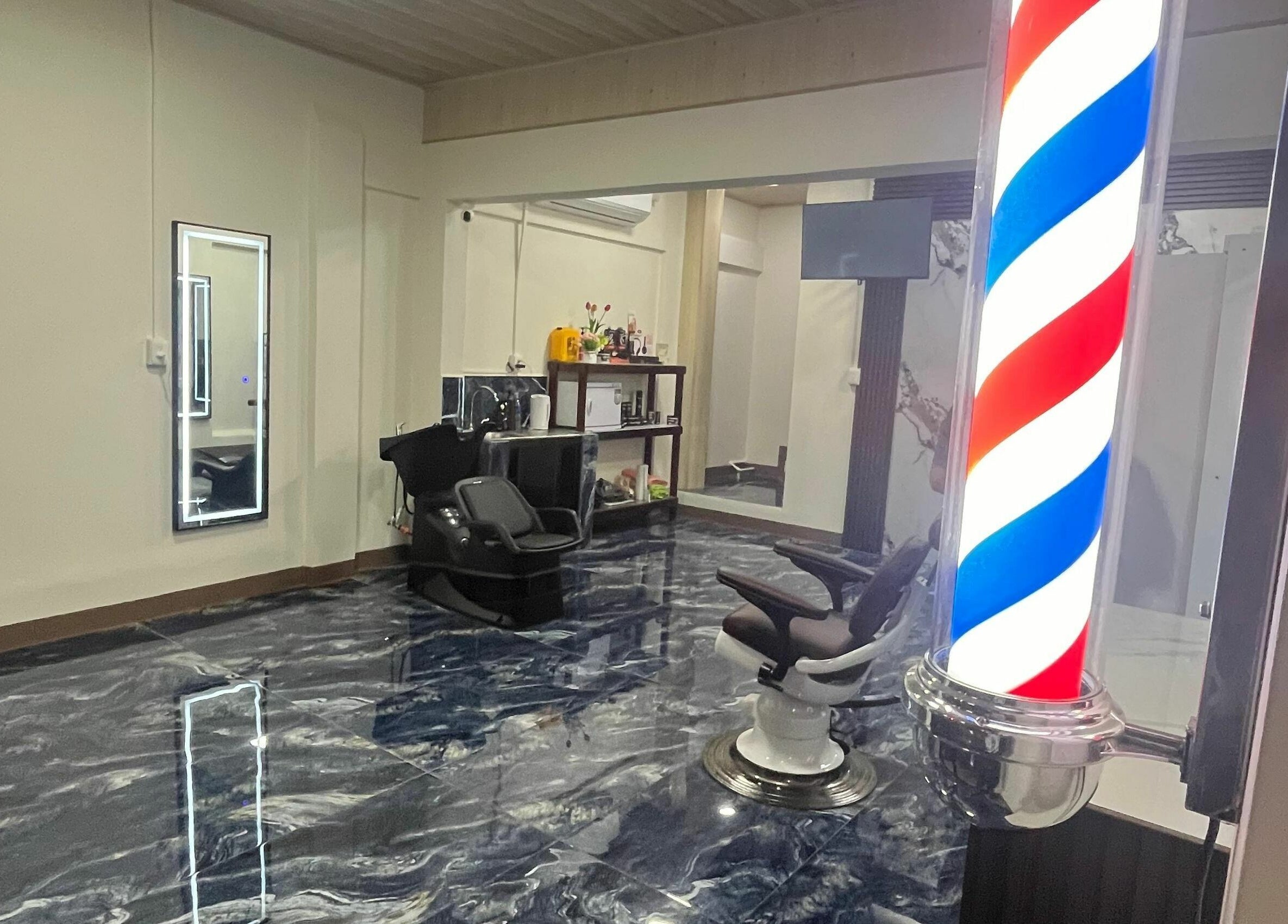Interior moderno de G Matices Barber en Guápiles, Limón, CR con silla de barbero y polea clásica.