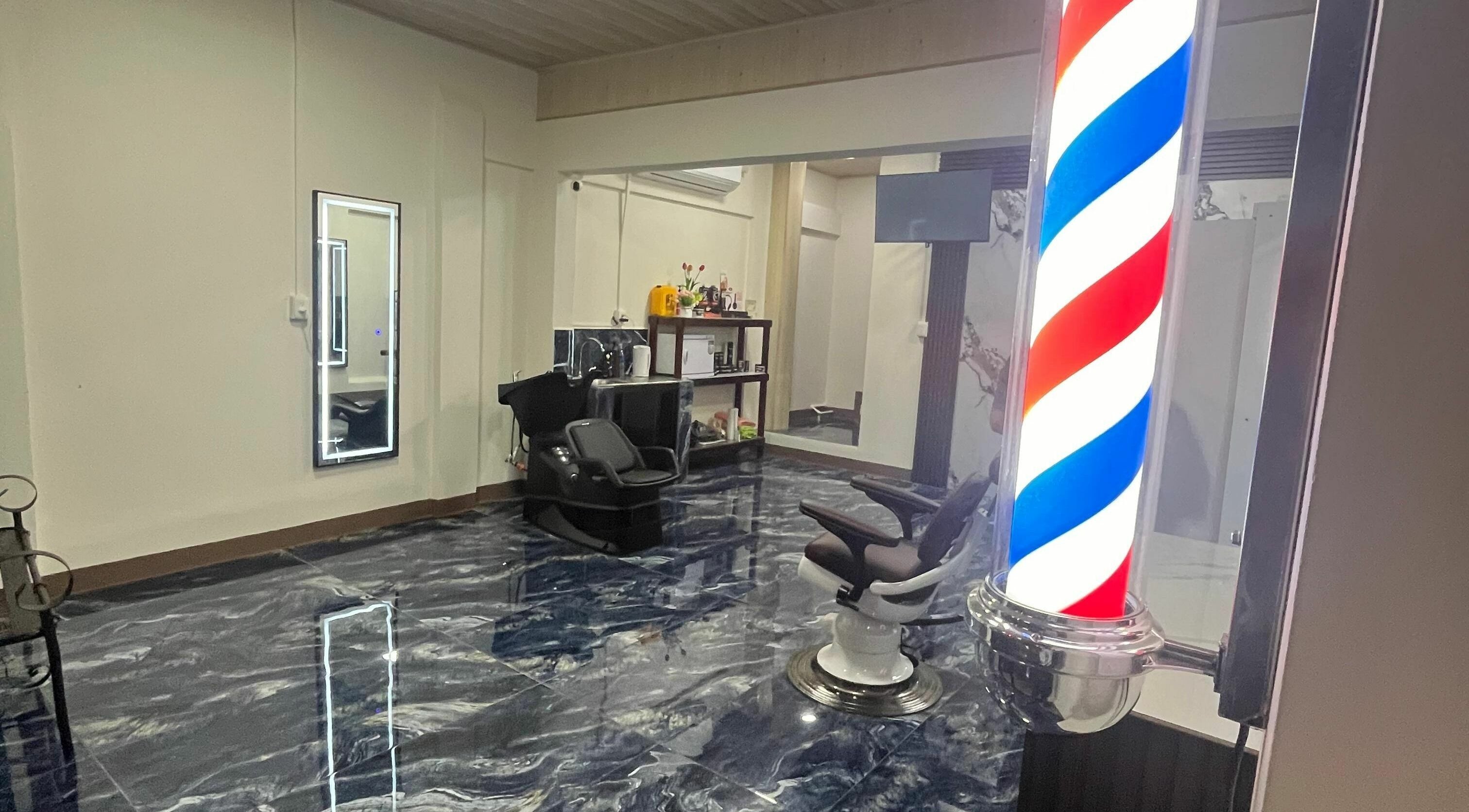 Interior moderno de G Matices Barber en Guápiles, Limón, CR con silla de barbero y polea clásica.
