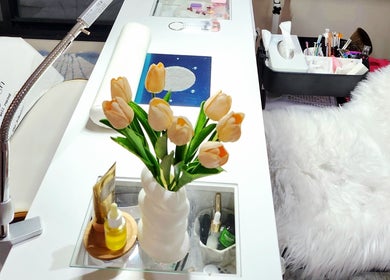 Chic nail station at NailxSejal, Melbourne, Victoria, AU, with white decor and yellow tulips.