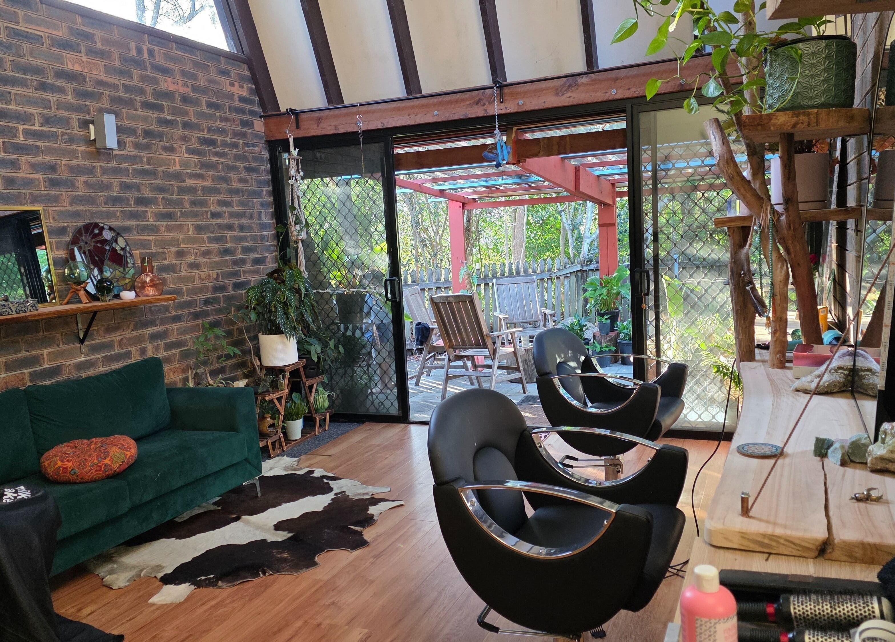 Relaxing interior of Nest Hair with stylish chairs and greenery in Shailer Park, Queensland, AU.