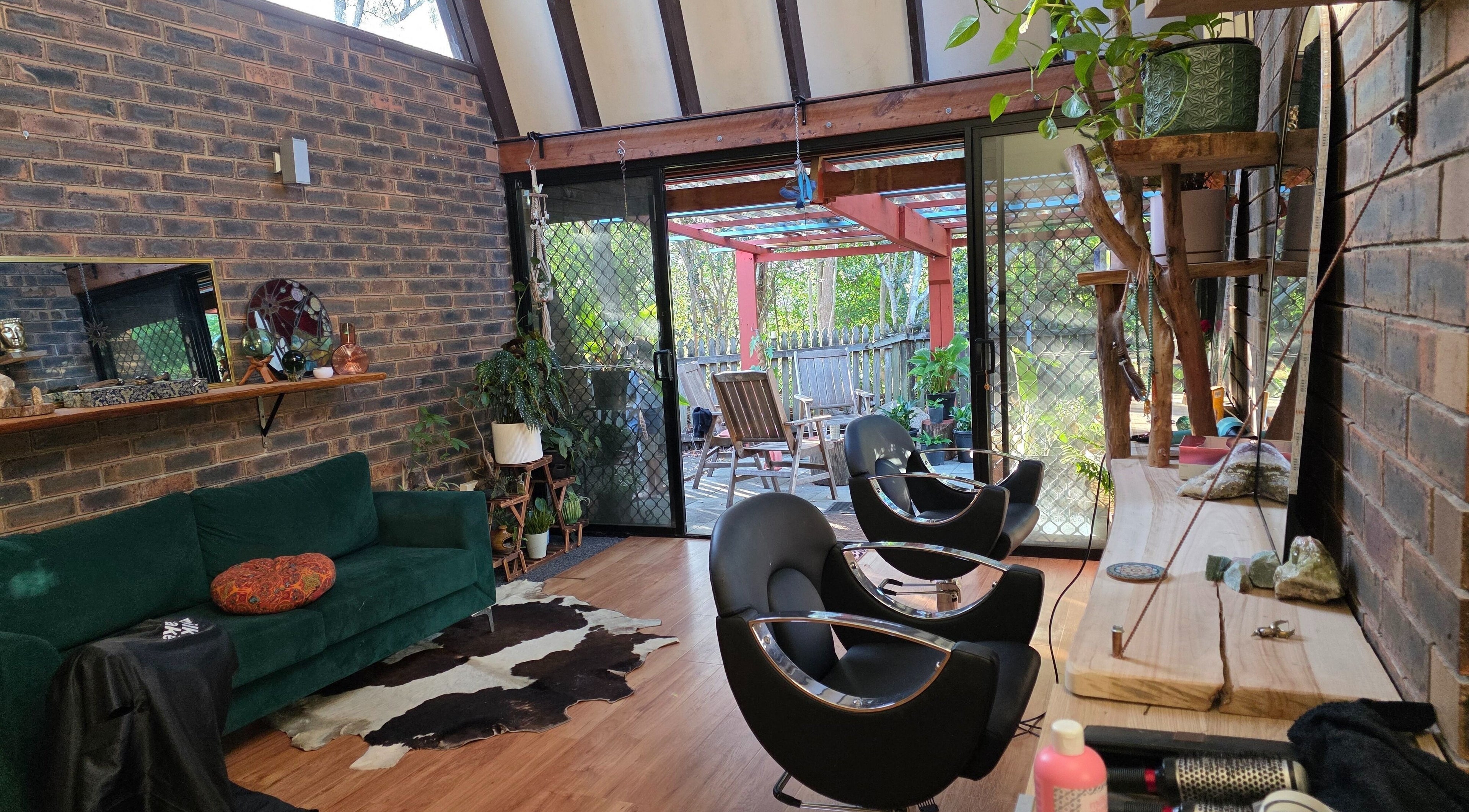 Relaxing interior of Nest Hair with stylish chairs and greenery in Shailer Park, Queensland, AU.