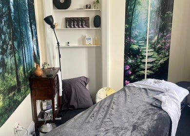 Tranquil therapy room at Hobart Massage Guru, Hobart, Tasmania, AU with forest-themed decor and massage table.