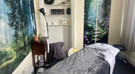 Tranquil therapy room at Hobart Massage Guru, Hobart, Tasmania, AU with forest-themed decor and massage table.