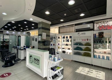 Modern interior of Nazih Gents Salon - Sharjah, showcasing stylish barber chairs and product shelves.