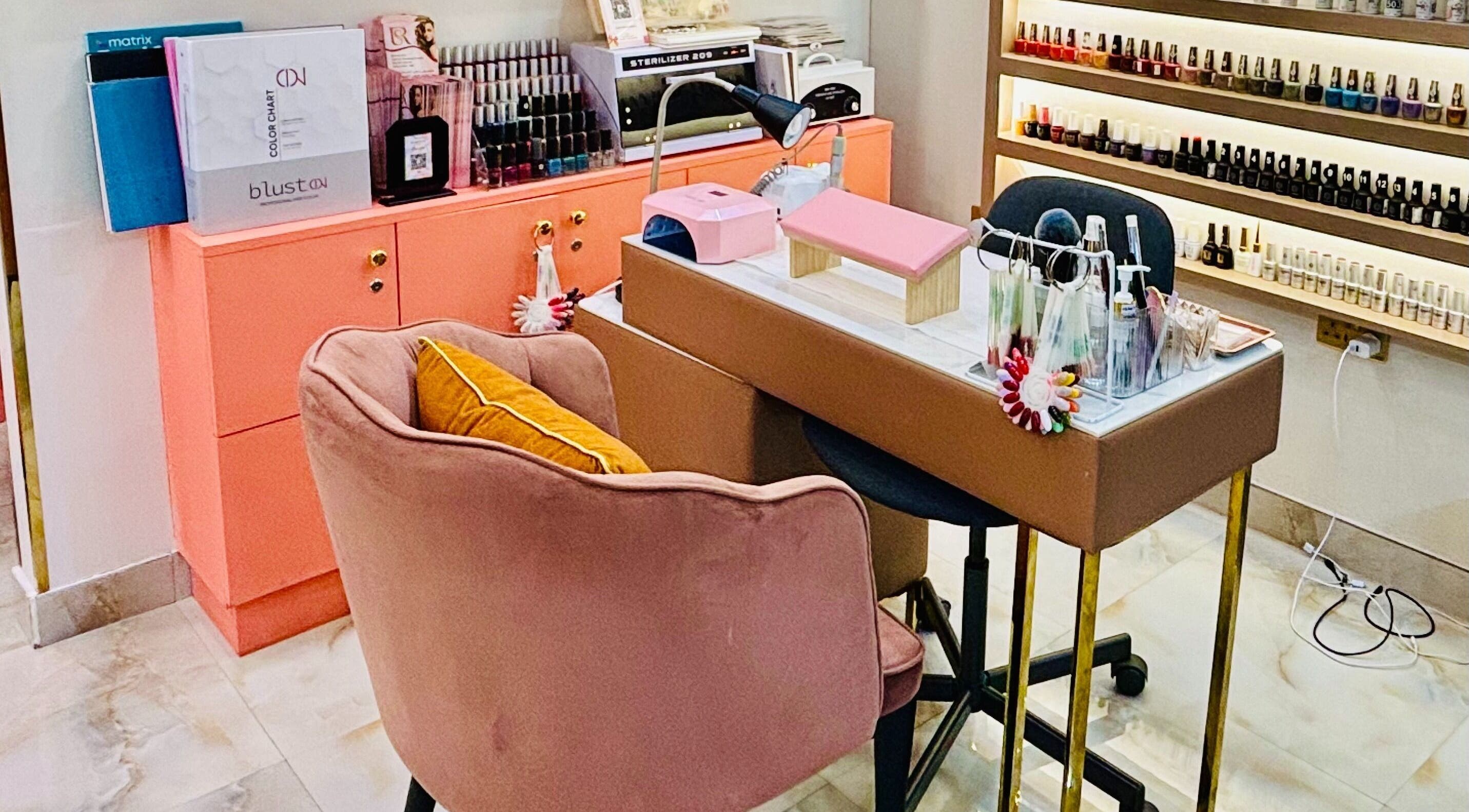 Manicure station at Sonyas Glam Beauty Salon, Dubai, Dubai, AE with plush chairs and nail polish display.