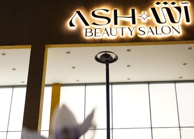 Illuminated Ash Center Salon facade in Madinah, Al Madinah Province, SA, glowing sign at night.