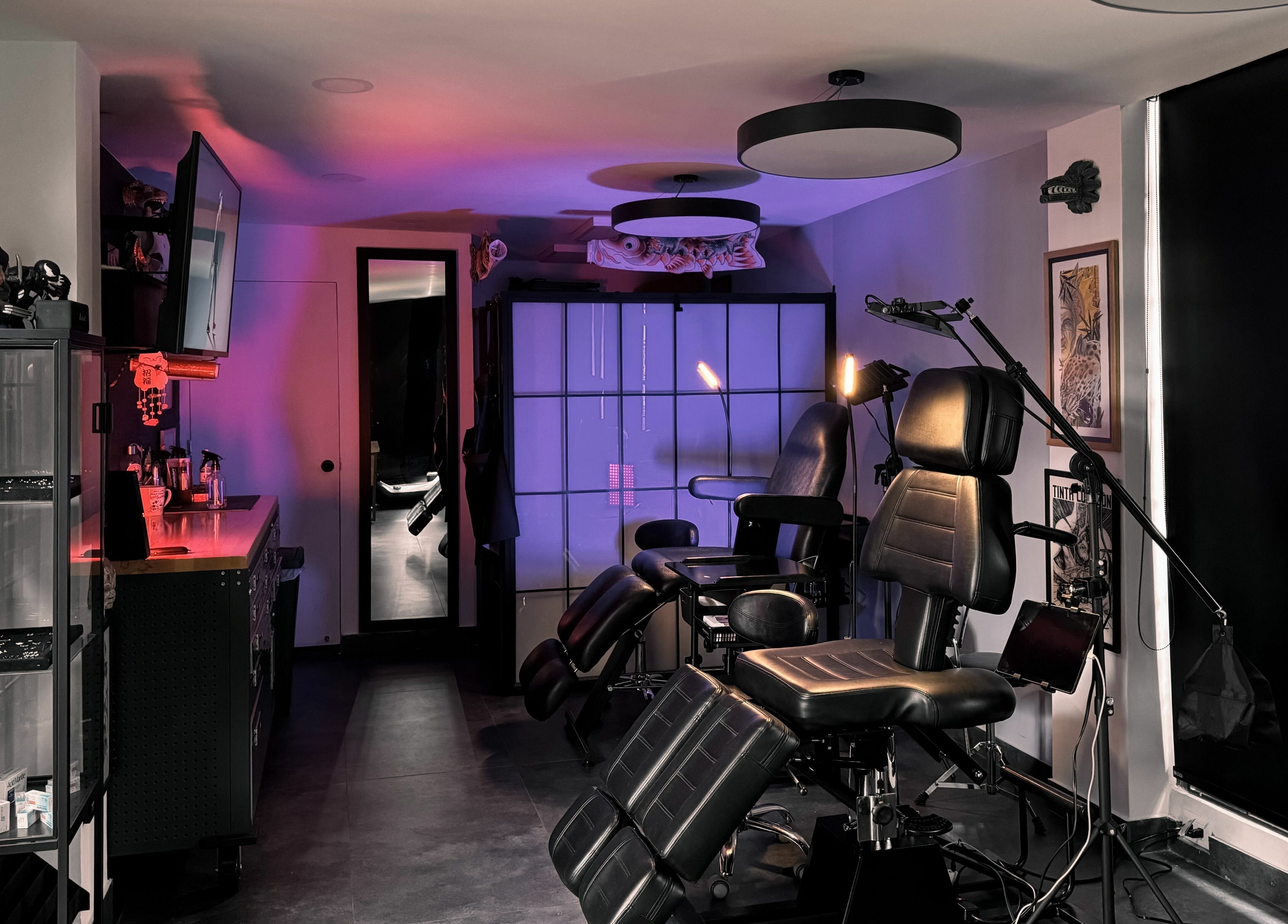 Interior de Black Beard's Tattoo Studio en Bogotá, CO con sillas de tatuaje y luz ambiente.