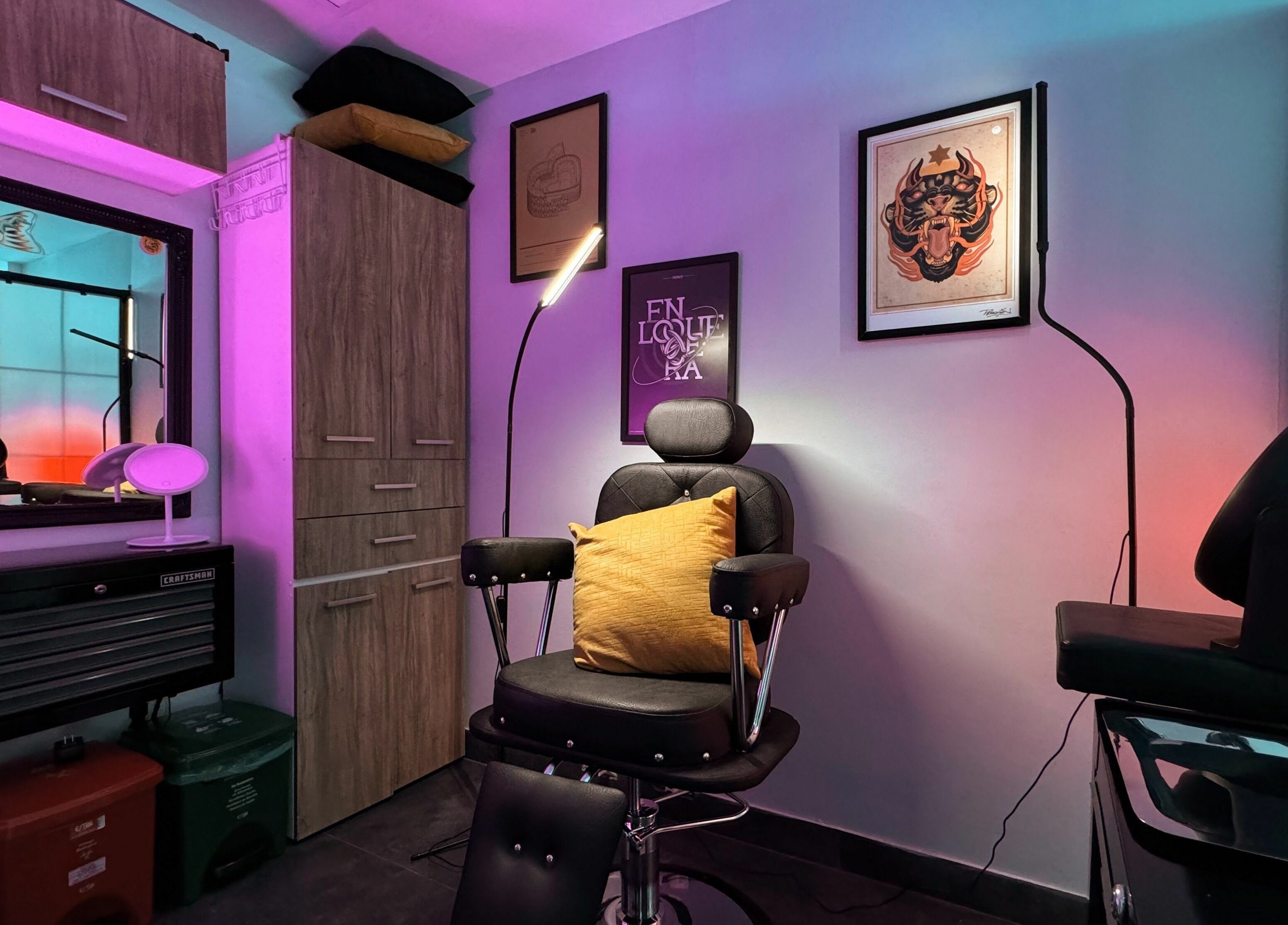 Silla de tatuaje en Black Beard's Tattoo Studio, Bogotá, Bogotá, CO, con iluminación colorida.