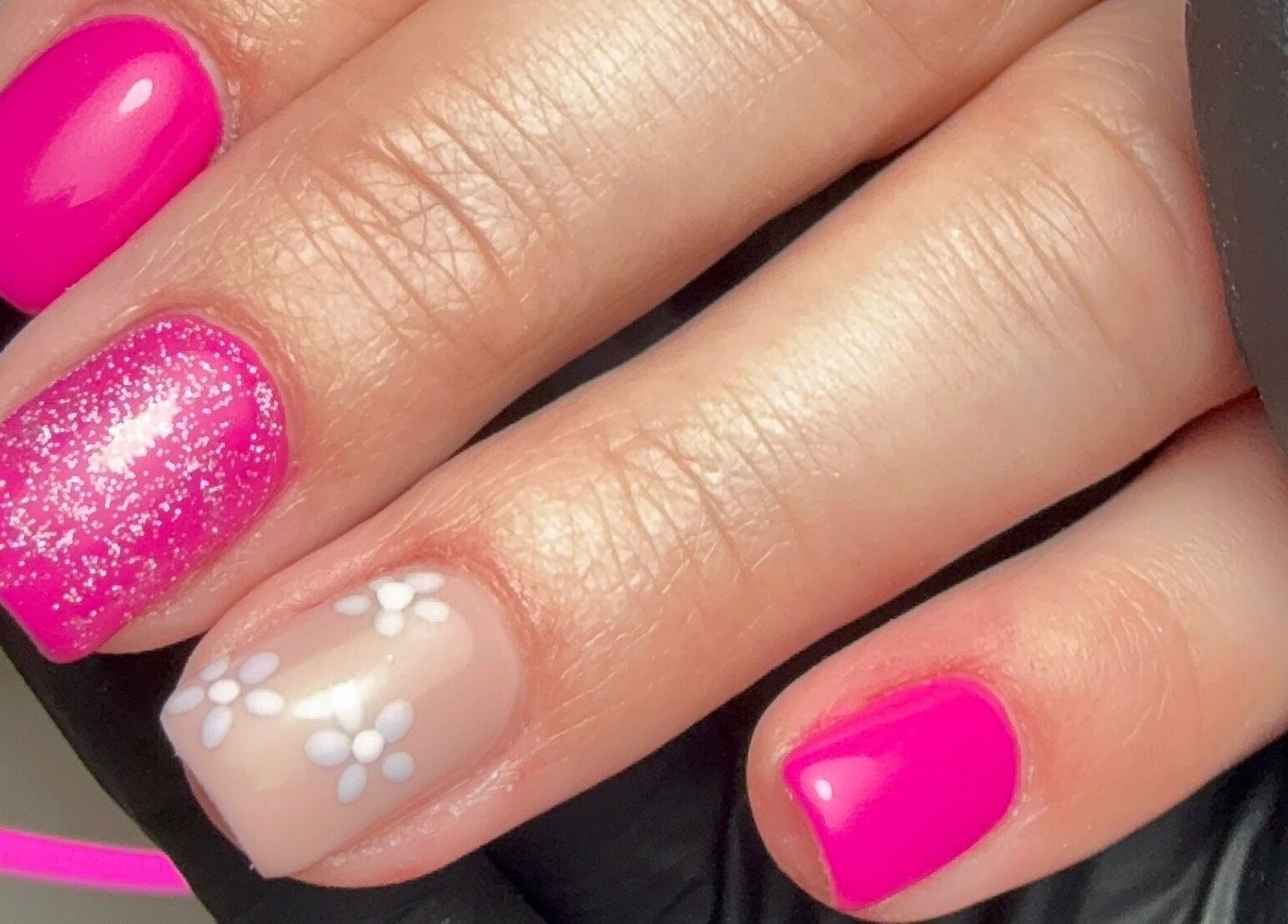 Vibrant pink and floral nail art at CXM Nails, Bangor, Northern Ireland, GB for a chic, stylish look.