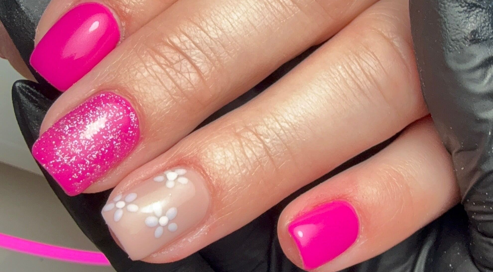 Vibrant pink and floral nail art at CXM Nails, Bangor, Northern Ireland, GB for a chic, stylish look.