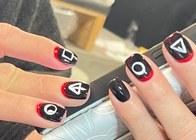 Stylish red and black geometric nail art at Xio’S Nails, Greensboro, North Carolina, US.
