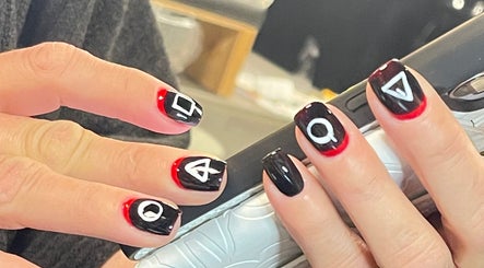 Stylish red and black geometric nail art at Xio’S Nails, Greensboro, North Carolina, US.