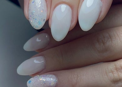 Elegant nail art with white and glitter tips at Xio's Nails, Greensboro, North Carolina, US.