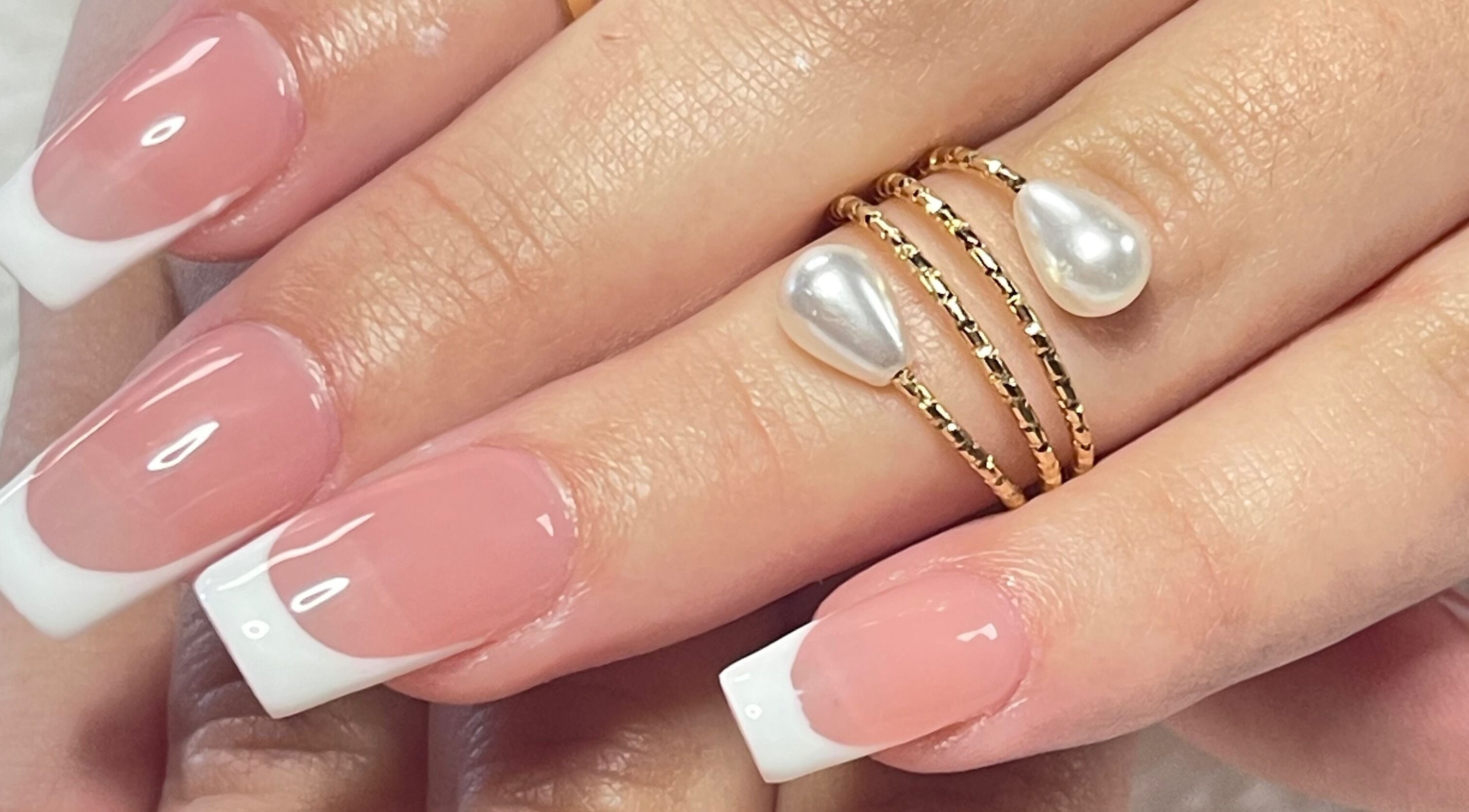 French manicure with pearl ring at Xio'S Nails, Greensboro, North Carolina, US.