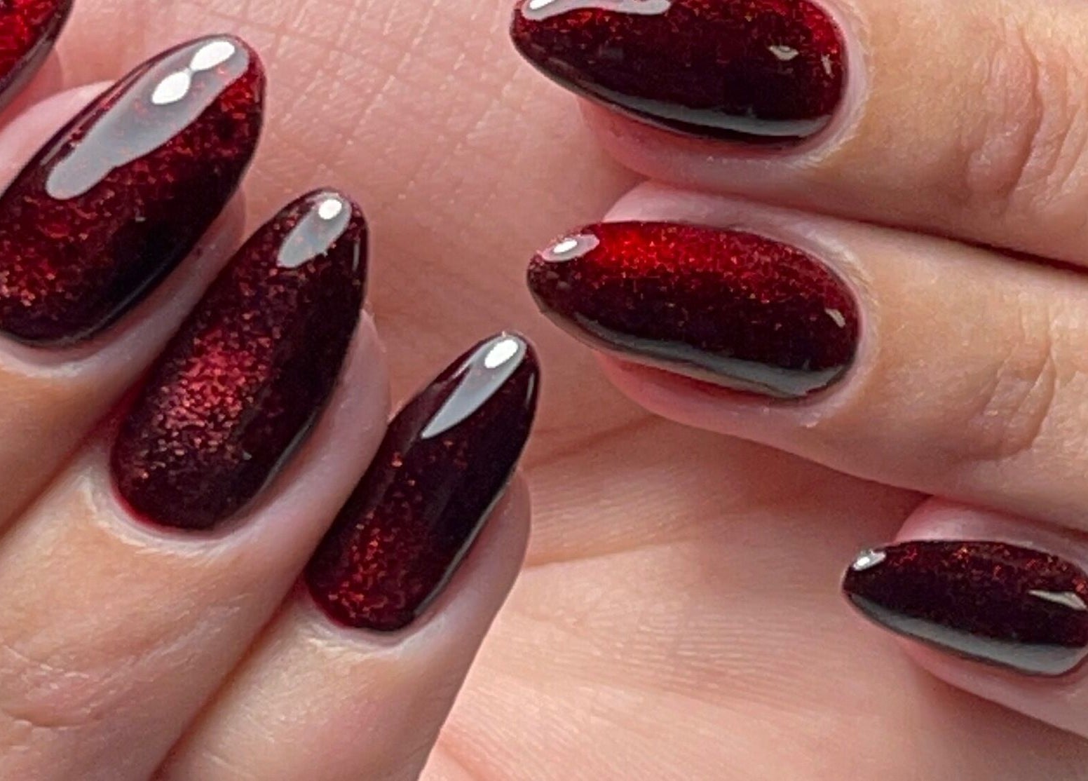 Close-up of ruby red glitter nails at Xio’s Nails, Greensboro, North Carolina, US.