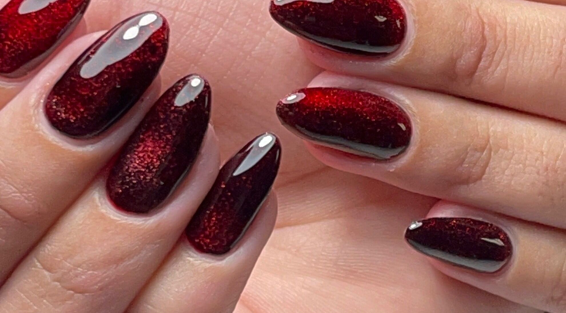 Close-up of ruby red glitter nails at Xio’s Nails, Greensboro, North Carolina, US.