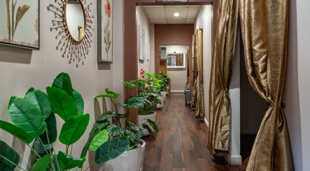 Serene corridor with plants and gold decor at Ancient Thai Massage in Los Angeles, California, US.