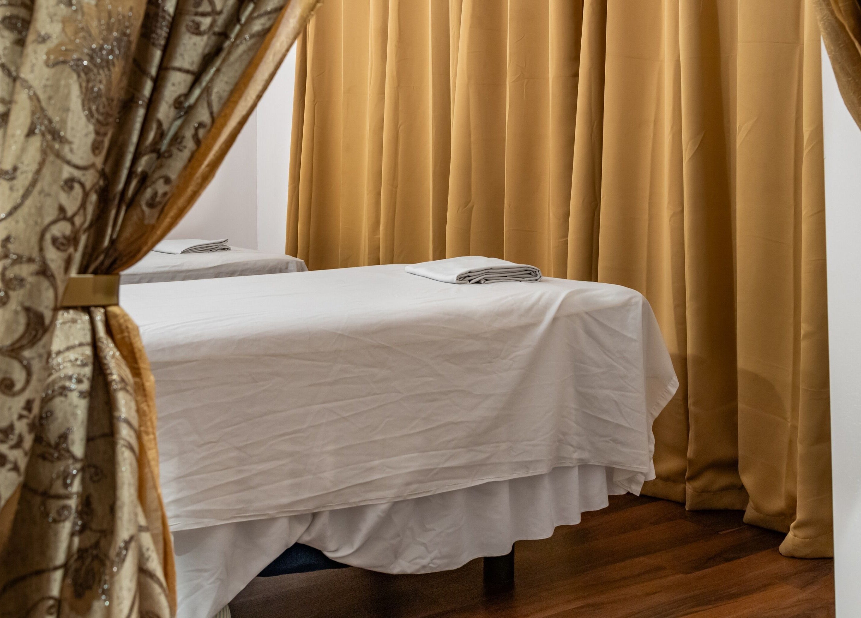 Peaceful massage room with bed and curtains at Ancient Thai Massage, Los Angeles, California, US.