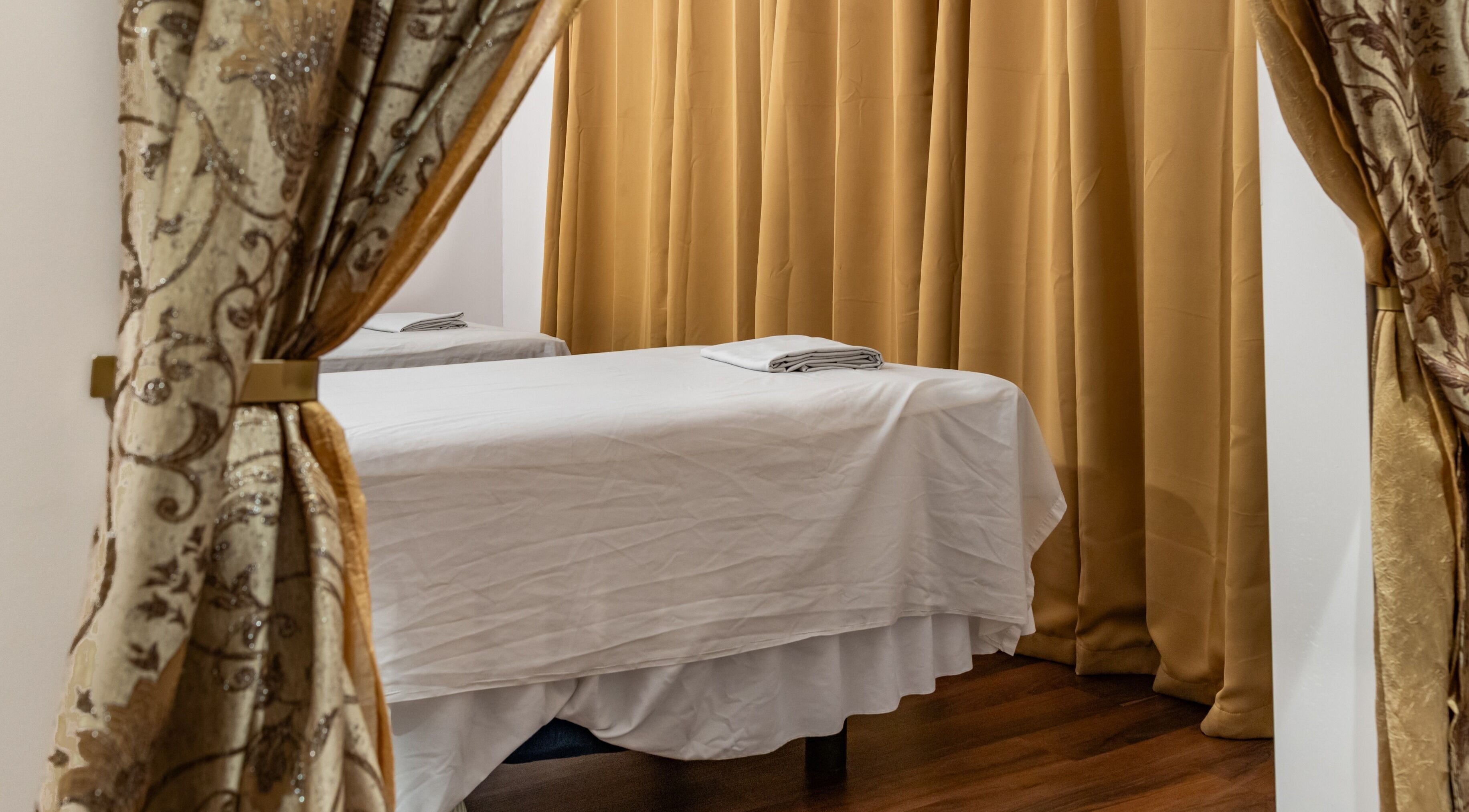 Peaceful massage room with bed and curtains at Ancient Thai Massage, Los Angeles, California, US.
