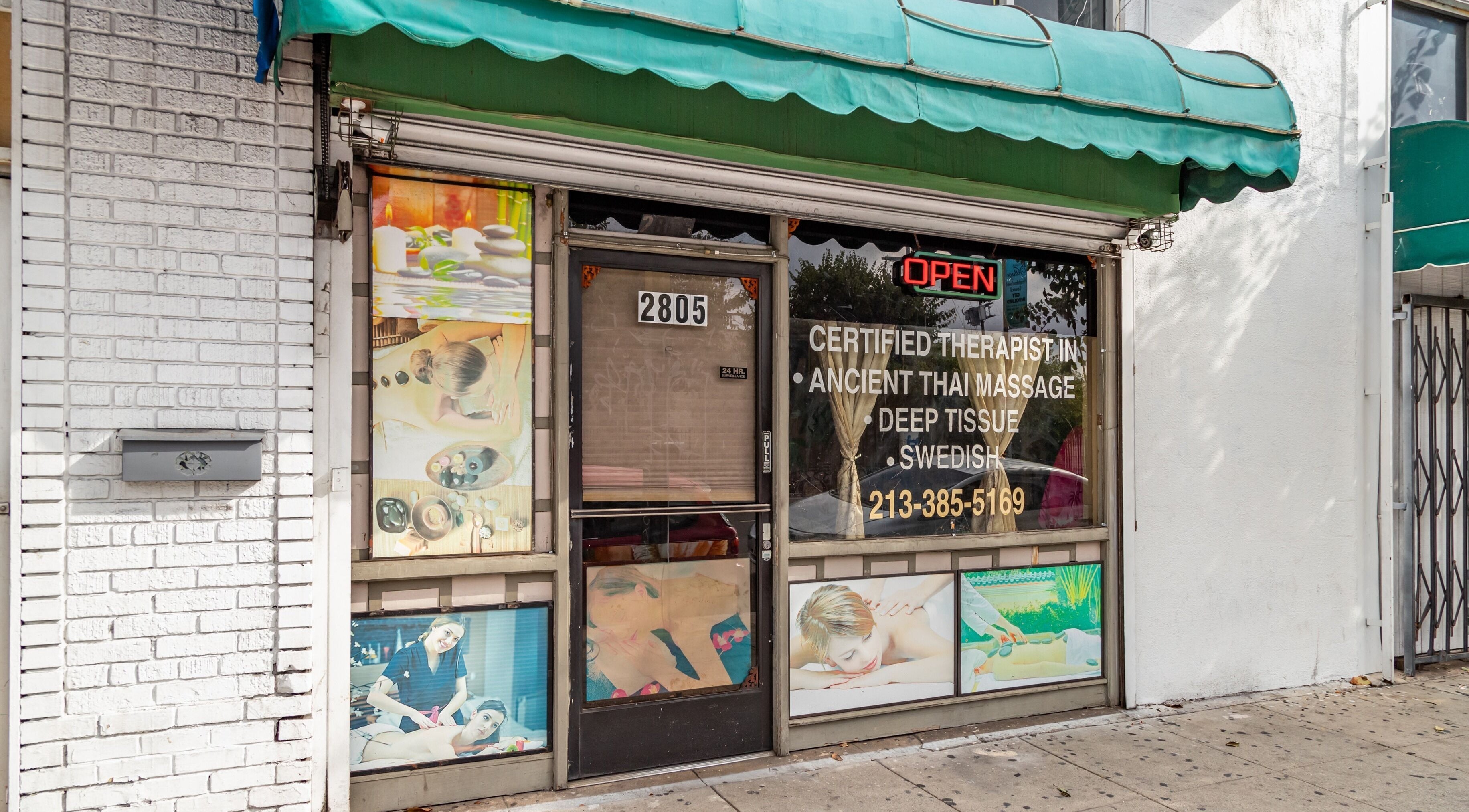 Exterior of Ancient Thai Massage, Los Angeles, California, US, inviting with a green awning and serene images.