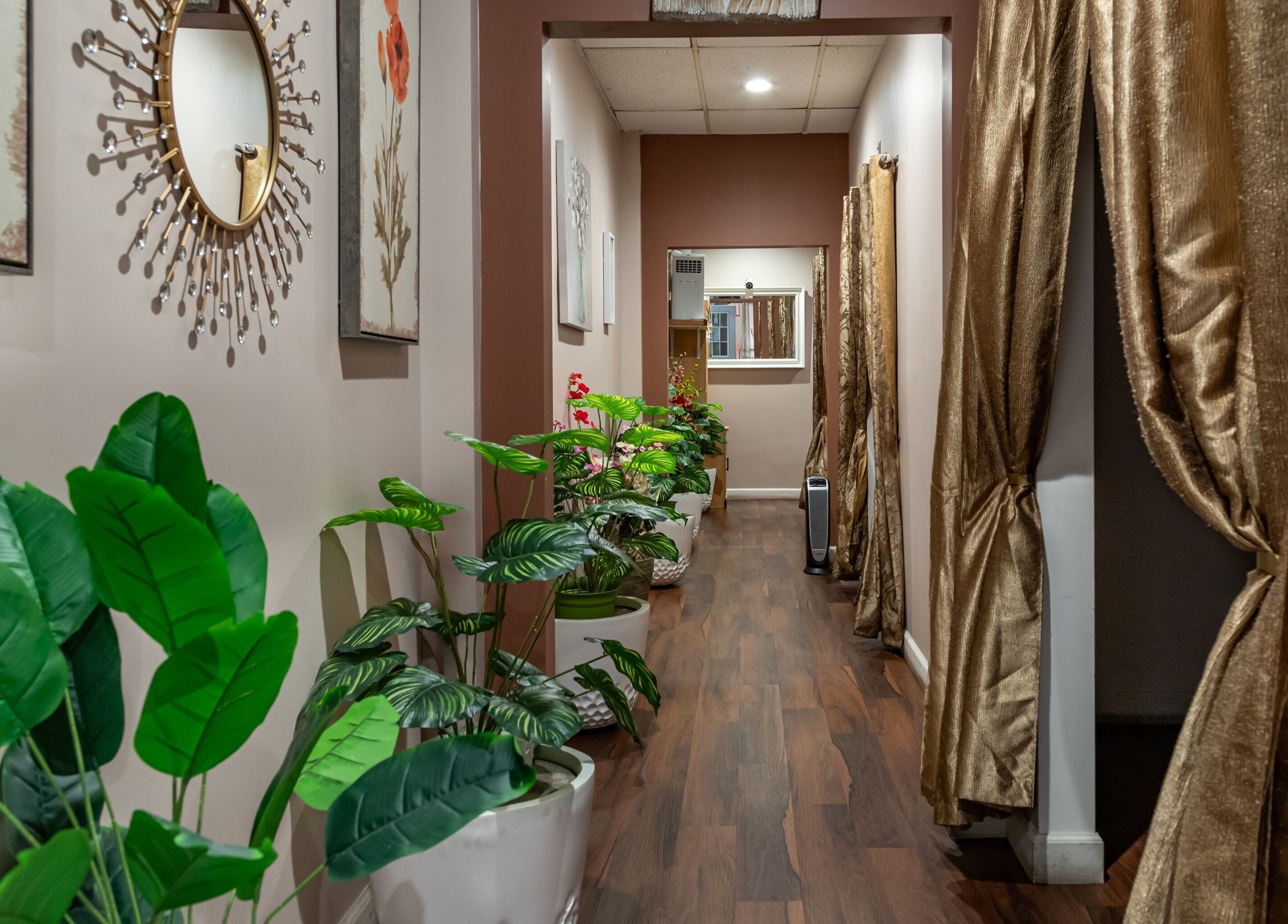 Elegant entrance at Ancient Thai Massage in Los Angeles, California, US with lush plants and golden curtains.