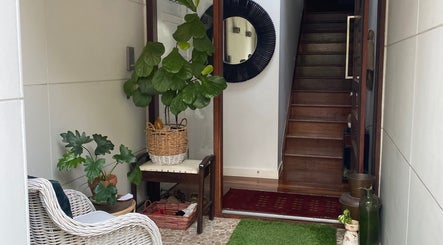 Inviting entrance of Larose Kinesiology, West End, Queensland, with lush plants and wicker seating.
