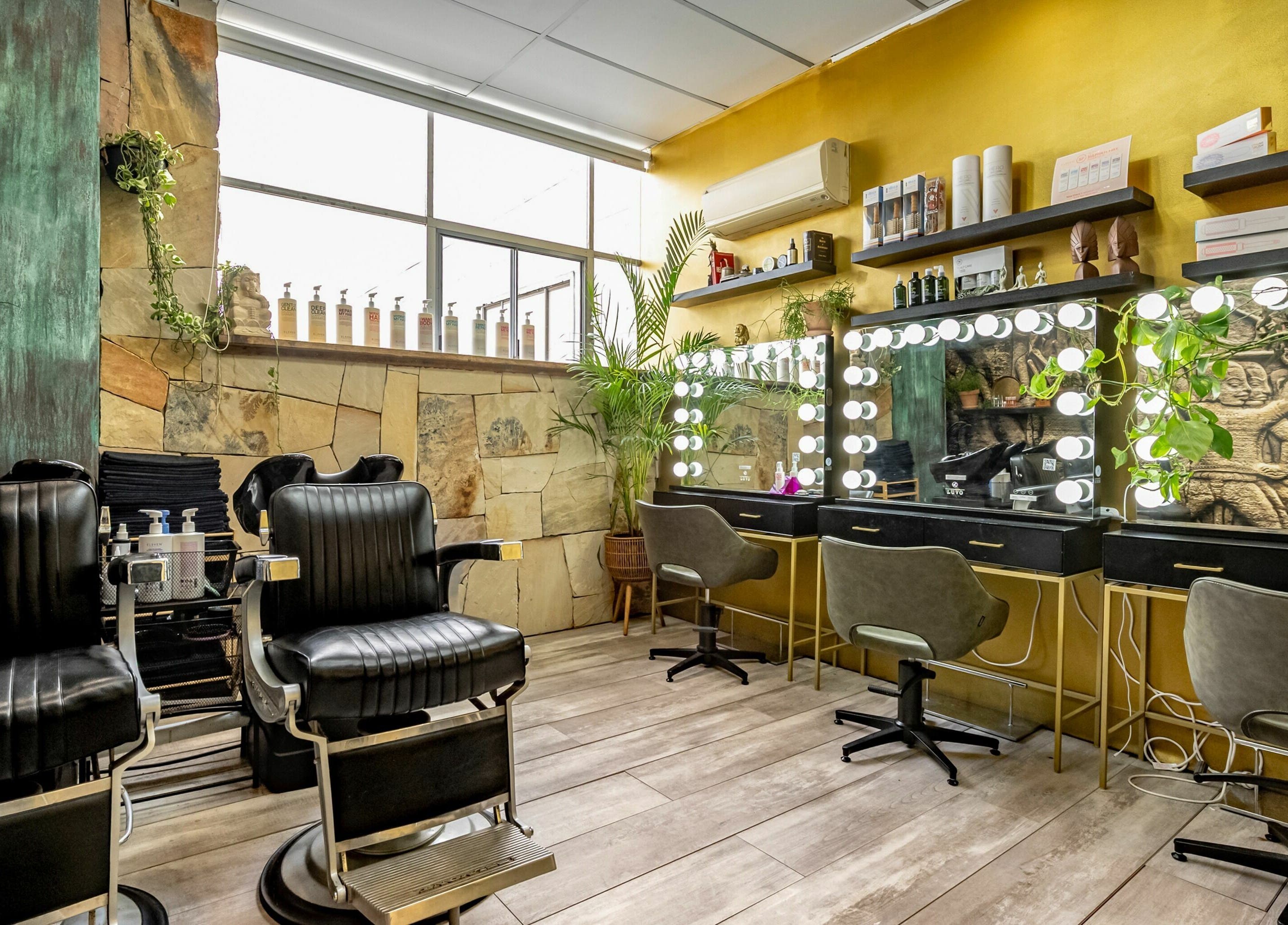 Elegant interior of Public Hair Studio, Brookvale, NSW, AU featuring modern styling chairs and illuminated mirrors.