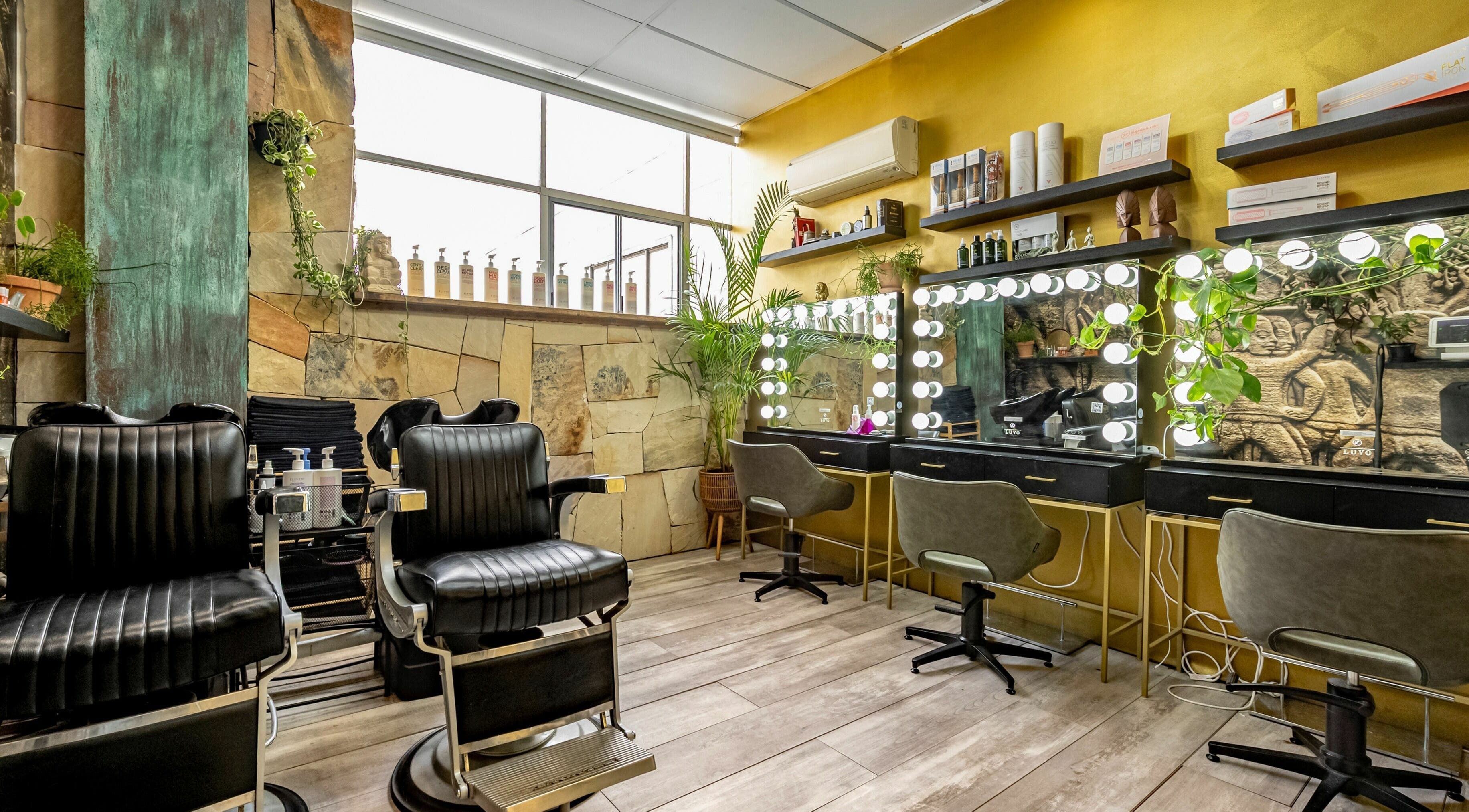 Elegant interior of Public Hair Studio, Brookvale, NSW, AU featuring modern styling chairs and illuminated mirrors.