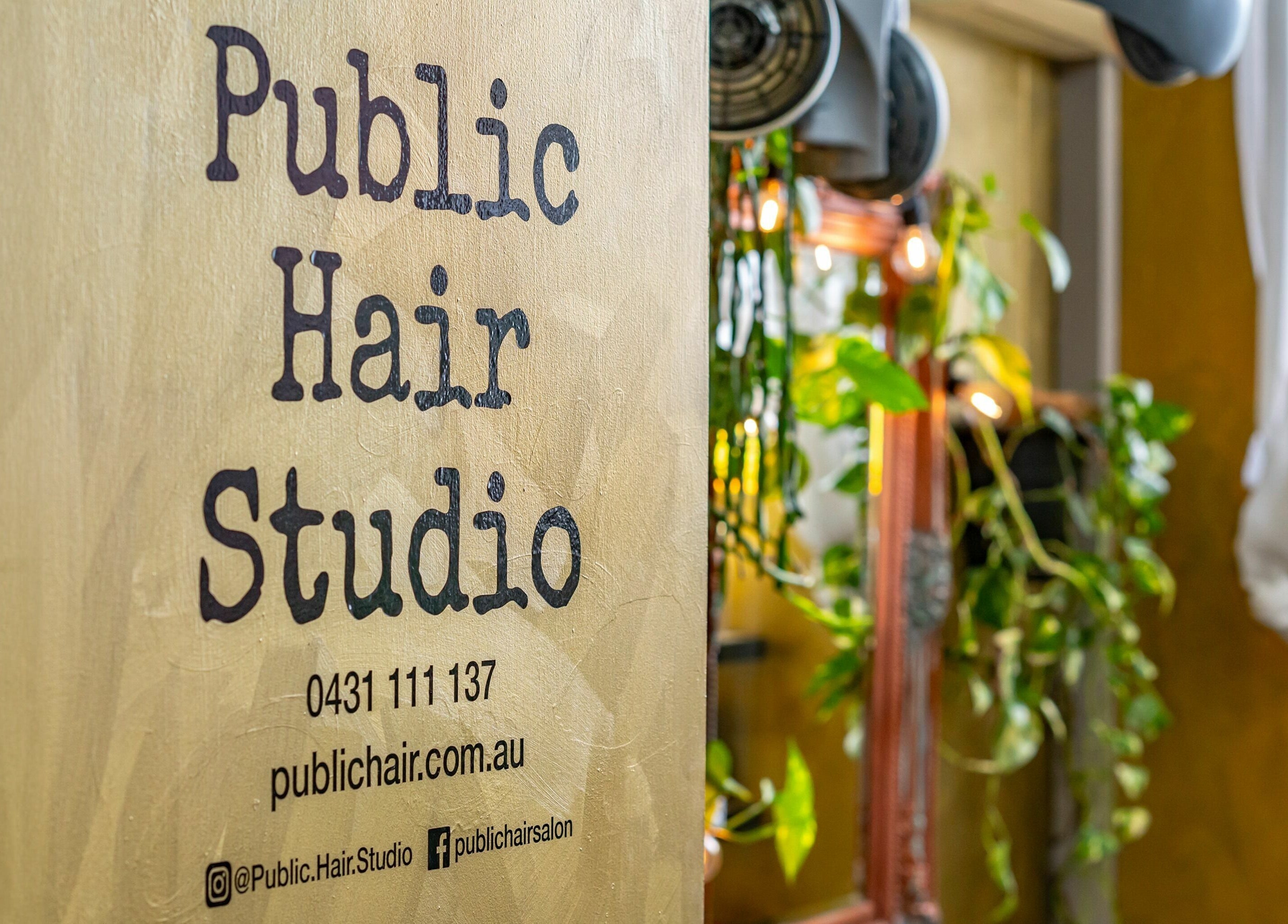 Public Hair Studio signage with lush plants, creating a welcoming atmosphere in Brookvale, NSW, AU.