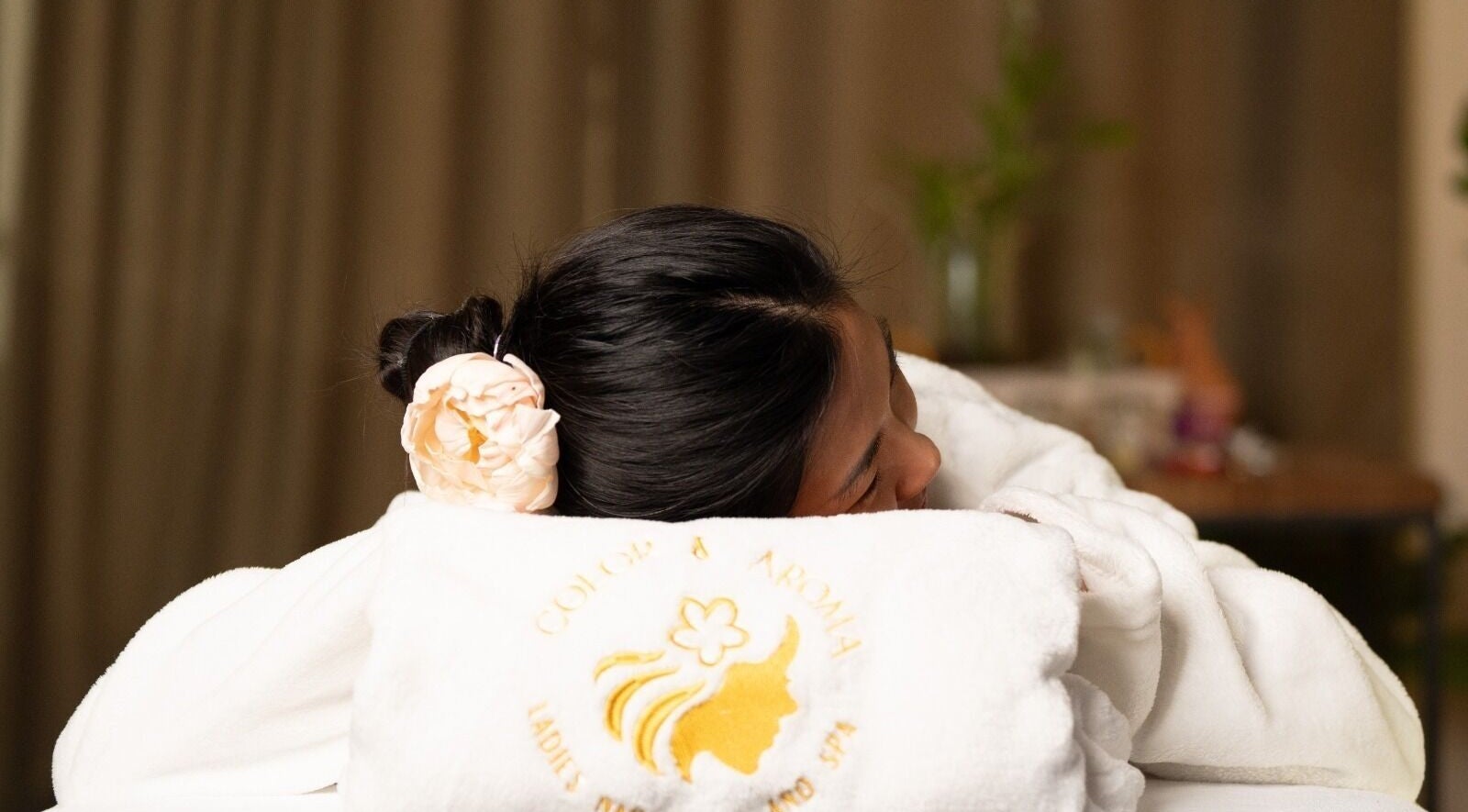 Client enjoying relaxation at Color & Aroma Nails and Spa in Dubai, AE, with a serene spa setting.